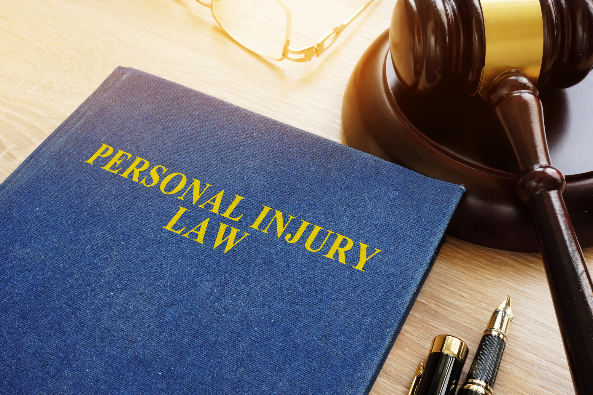 Personal Injury FAQs - Personal injury law on a desk and gavel.