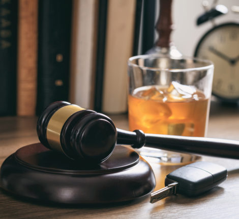DUI: A Dangerous & Selfish Habit - Law gavel, alcohol and car keys on a wooden desk, dark background