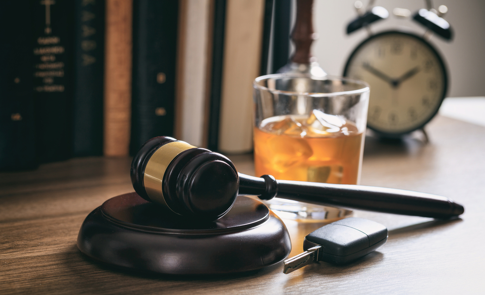 DUI: A Dangerous & Selfish Habit - Law gavel, alcohol and car keys on a wooden desk, dark background